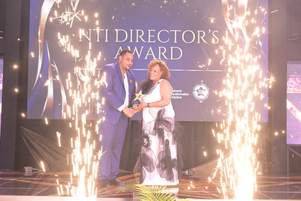 Fabian Branch and Dr. The Hon. Allyson Leacock on stage at the NTI Director’s Award, with sparklers either side